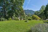 Experience breathtaking mountain views from this serene property, featuring a lush green lawn perfect for relaxation and outdoor activities.