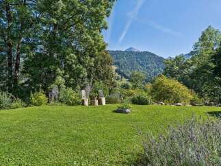 Experience breathtaking mountain views from this serene property, featuring a lush green lawn perfect for relaxation and outdoor activities.