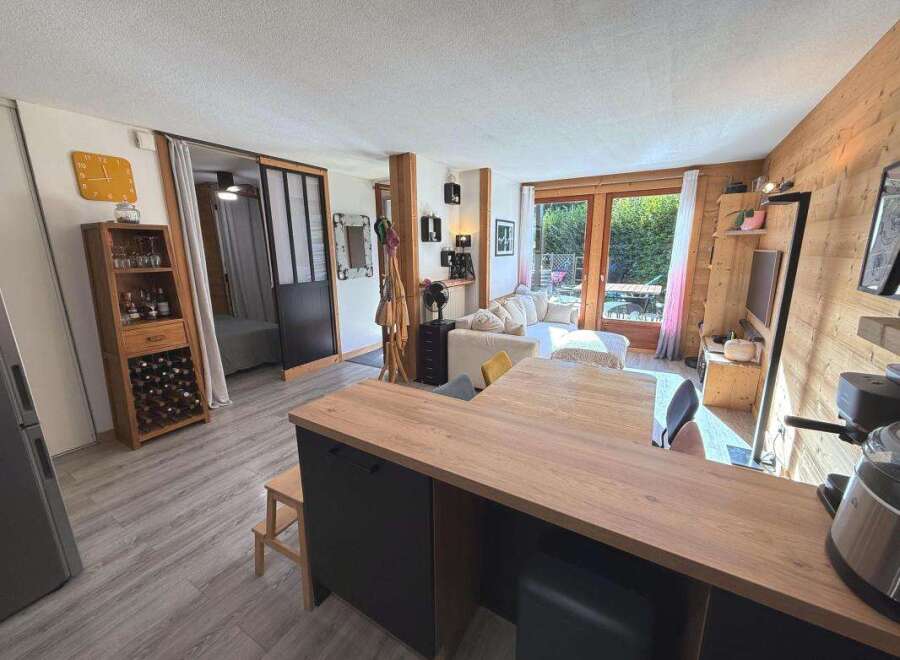 Discover this charming apartment featuring a cozy living area with a comfortable sofa and a modern kitchen island, perfect for entertaining.