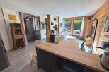 Discover this charming apartment featuring a cozy living area with a comfortable sofa and a modern kitchen island, perfect for entertaining.