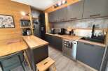 Discover this modern kitchen featuring sleek grey cabinetry and warm wooden countertops, perfect for a cozy yet functional living space.