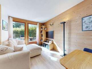 Experience cozy living in this charming mountain retreat, featuring a comfortable sectional sofa and a warm, wood-paneled living area.