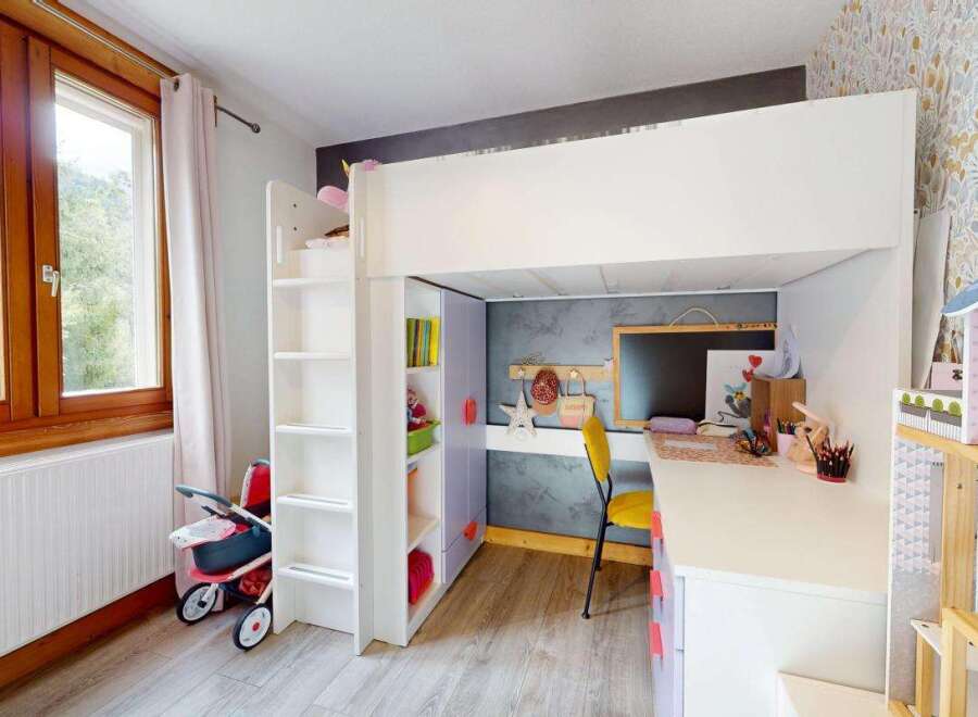 This charming children's room features a space-saving loft bed with an integrated desk and shelving, perfect for study and play.