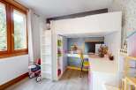 This charming children's room features a space-saving loft bed with an integrated desk and shelving, perfect for study and play.