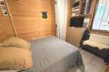 Experience cozy mountain living in this charming bedroom featuring warm wood paneling and a comfortable bed.