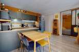 Discover this charming studio apartment featuring a modern kitchenette with sleek grey cabinetry and integrated appliances, perfect for preparing meals.