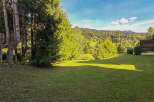 Experience the charm of this mountain property, featuring a spacious green lawn perfect for outdoor activities and relaxation.