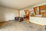 This spacious living area features a cozy brown sofa with decorative pillows, perfect for relaxing.