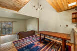 Experience rustic charm in this inviting living space, featuring a vaulted wood-paneled ceiling and a cozy seating area.