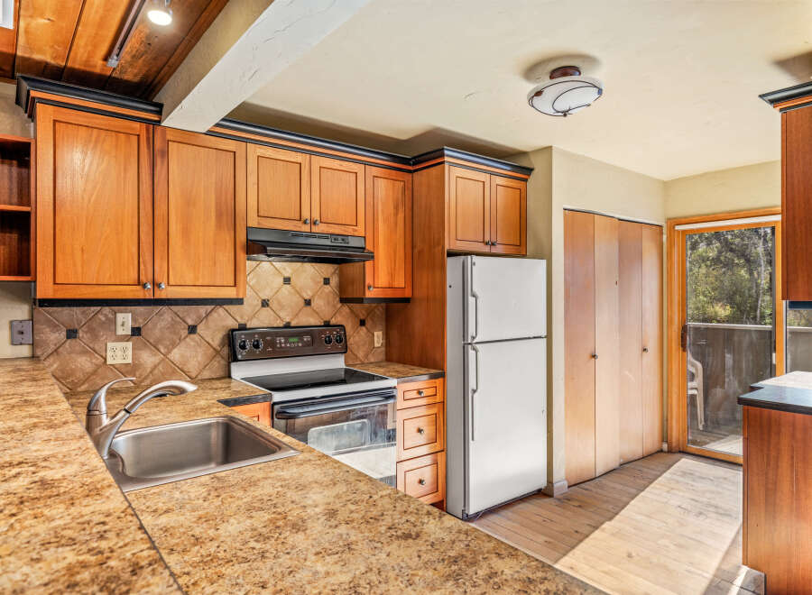 Discover this charming kitchen featuring warm wood cabinetry and a sleek granite countertop.