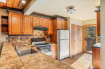Discover this charming kitchen featuring warm wood cabinetry and a sleek granite countertop.