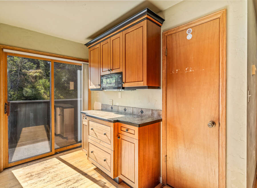Discover this charming kitchen featuring warm wooden cabinetry and a convenient microwave.