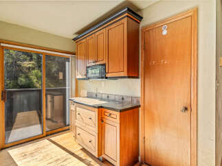 Discover this charming kitchen featuring warm wooden cabinetry and a convenient microwave.