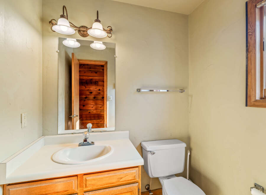This bathroom features a classic vanity with a white sink and ample counter space, complemented by warm wooden cabinetry.