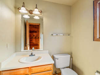 This bathroom features a classic vanity with a white sink and ample counter space, complemented by warm wooden cabinetry.