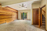 This spacious living area features a striking accent wall of warm wood paneling, creating a cozy and inviting atmosphere.