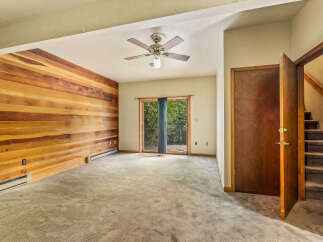 This spacious living area features a striking accent wall of warm wood paneling, creating a cozy and inviting atmosphere.