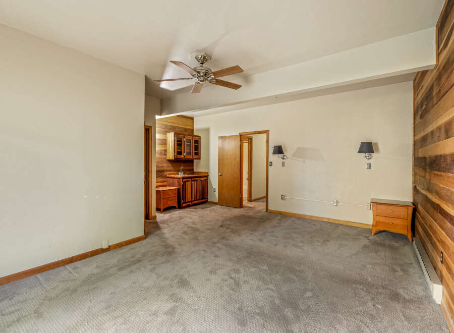 Discover this charming space featuring a built-in wet bar with rich wooden cabinetry, perfect for entertaining.