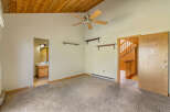 Step into this charming room featuring a vaulted wood-paneled ceiling and a ceiling fan for optimal comfort.