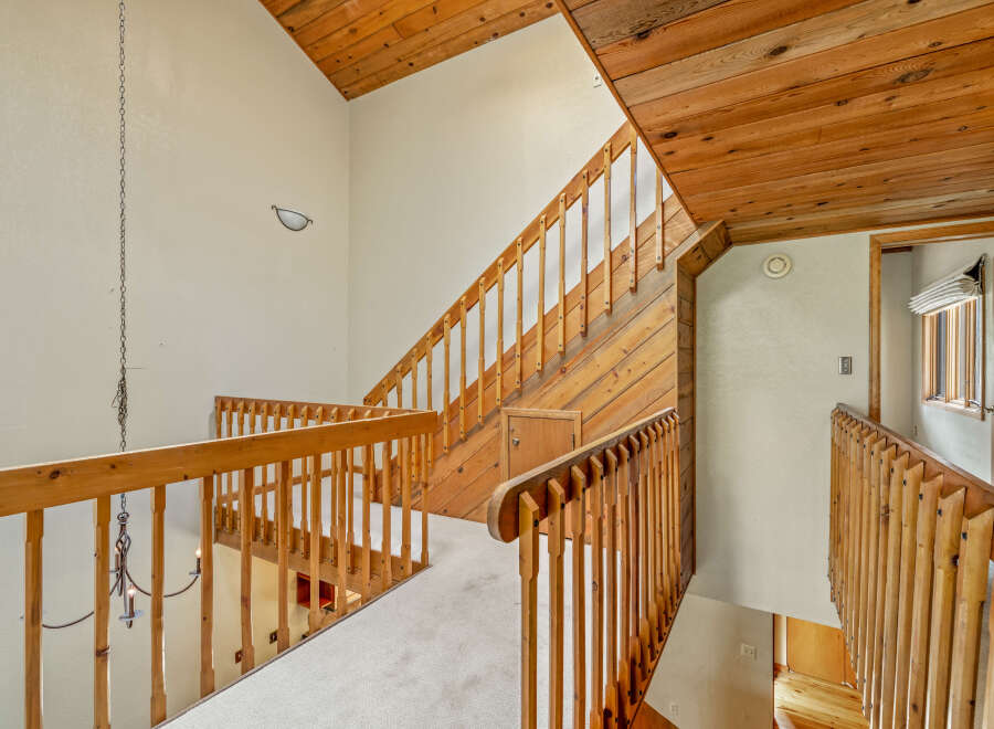 Ascend to the upper level of this charming home via the beautifully crafted wooden staircase, featuring a warm, natural wood finish.