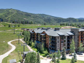 Experience luxury mountain living in this stunning condominium complex, perfectly situated amidst rolling green hills and majestic peaks.