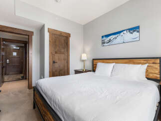 Experience ultimate comfort in this inviting bedroom, featuring a plush king-sized bed adorned with crisp white linens.
