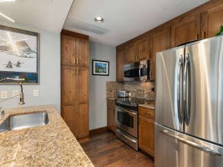 Experience modern comfort in this well-appointed kitchen, featuring sleek stainless steel appliances including a refrigerator and microwave.