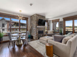 Experience modern mountain living in this beautifully appointed living space, featuring a stunning stone fireplace as the centerpiece.