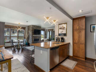 Experience modern mountain living in this stunning open-concept condo, featuring a gourmet kitchen with granite countertops and stainless steel appliances.