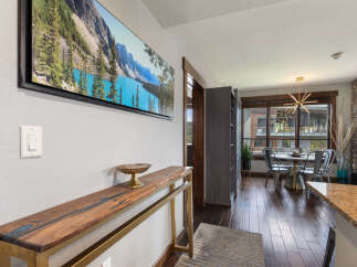 This stunning entryway features a striking live-edge wood console table with a blue resin inlay, complemented by a large landscape artwork above.