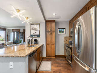 Experience modern mountain living in this stunning kitchen, featuring sleek stainless steel appliances, granite countertops, and rich wood cabinetry.