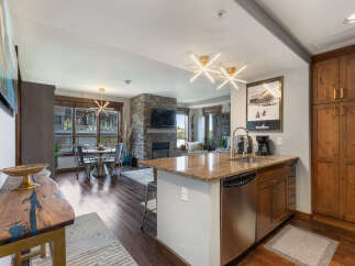 Experience modern mountain living in this stunning open-concept condo, featuring a gourmet kitchen with granite countertops and stainless steel appliances.