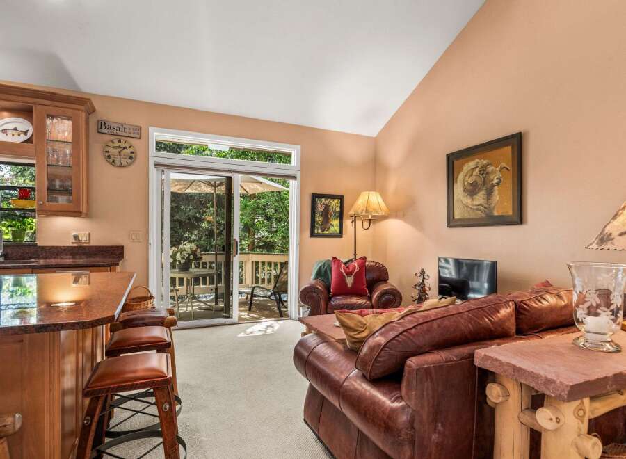 Experience comfortable living in this inviting living space, featuring a cozy leather sofa and armchair perfect for relaxation.
