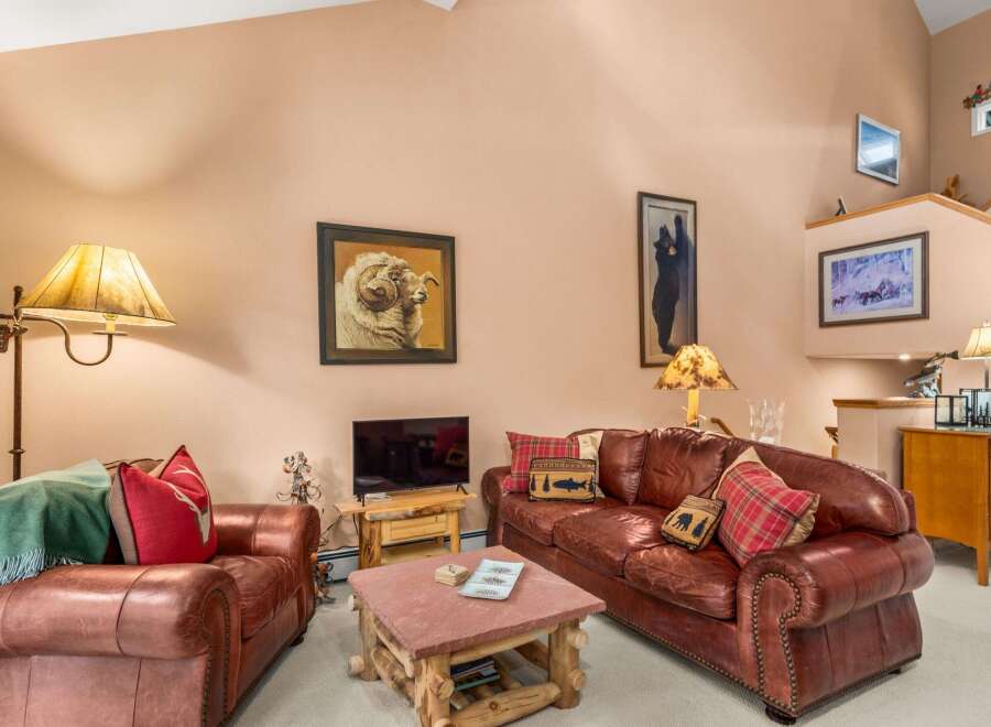 Experience rustic charm in this inviting living room, featuring plush leather sofas and a cozy stone coffee table.
