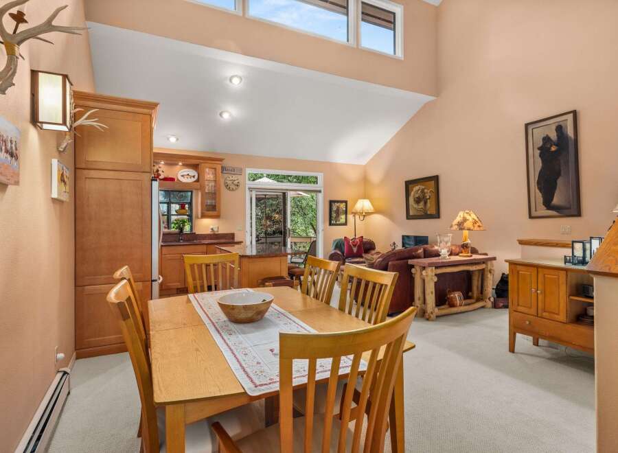 Experience rustic charm in this inviting dining and living area, featuring a warm wooden dining set perfect for family meals.