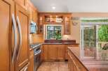 This spacious kitchen boasts beautiful cherry wood cabinetry and granite countertops, offering a warm and inviting atmosphere.