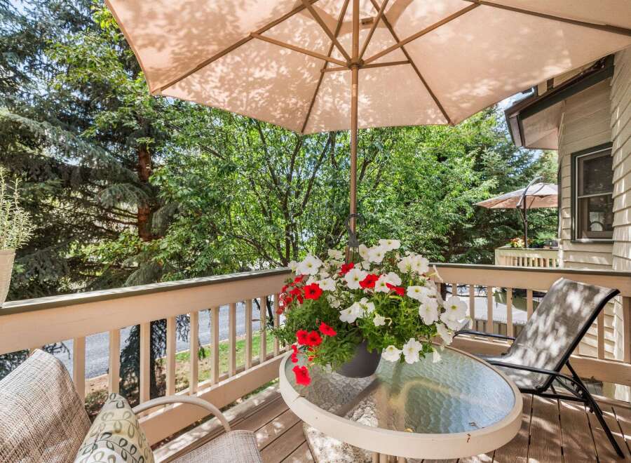 Enjoy your morning coffee on this charming balcony, complete with a glass-top table and comfortable seating.