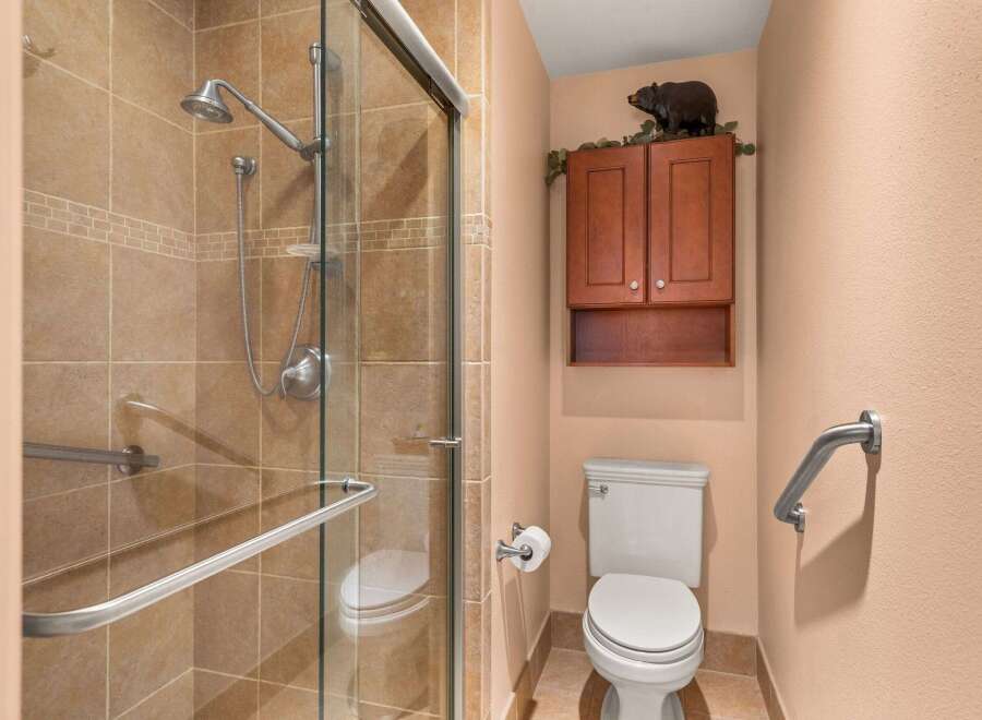 This bathroom features a spacious walk-in shower with elegant tilework and a convenient grab bar.