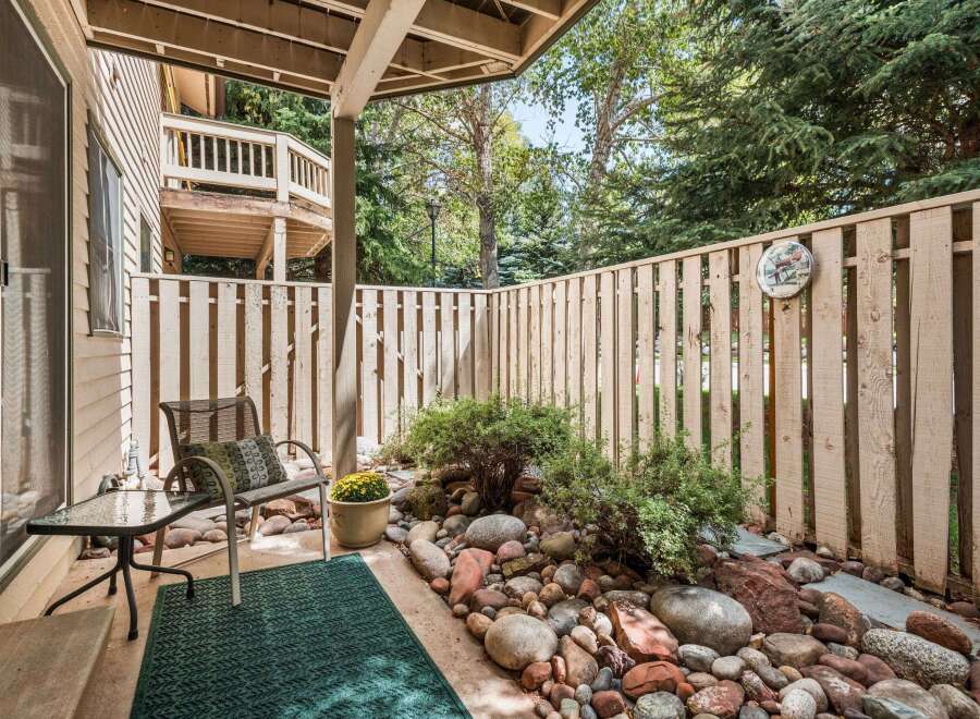 Enjoy private outdoor living on this charming patio, complete with a comfortable seating area and a decorative rock garden.