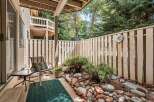 Enjoy private outdoor living on this charming patio, complete with a comfortable seating area and a decorative rock garden.