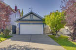 Charming home featuring a classic white garage door with blue trim and house number 13.