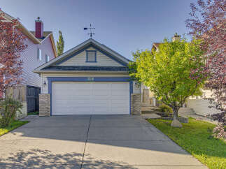 Charming home featuring a classic white garage door with blue trim and house number 13.