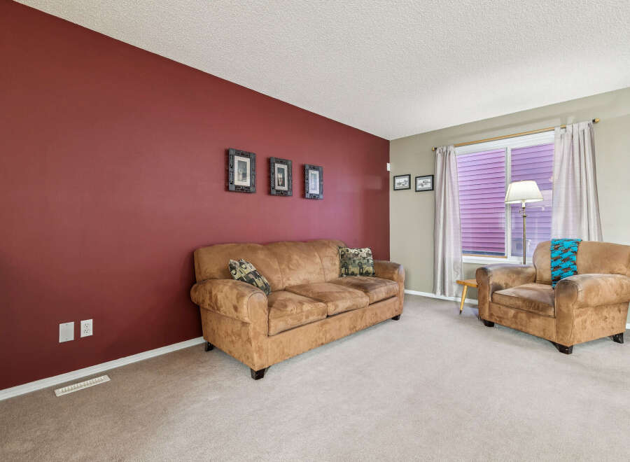 Step into this inviting living room featuring a plush brown sofa and a comfortable armchair, perfect for relaxation.
