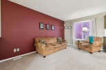 Step into this inviting living room featuring a plush brown sofa and a comfortable armchair, perfect for relaxation.