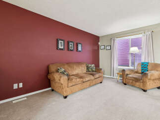 Step into this inviting living room featuring a plush brown sofa and a comfortable armchair, perfect for relaxation.