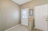 Step into a welcoming entryway featuring a bright front door with a decorative sheer curtain, perfect for letting in natural light.