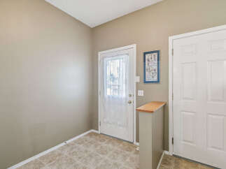 Step into a welcoming entryway featuring a bright front door with a decorative sheer curtain, perfect for letting in natural light.