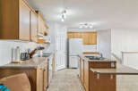 This spacious kitchen features warm oak cabinetry and ample counter space, perfect for meal preparation.