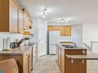 This spacious kitchen features warm oak cabinetry and ample counter space, perfect for meal preparation.