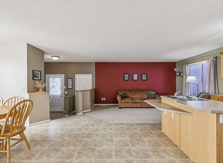 Discover an open-concept living space perfect for entertaining, featuring a seamless flow between the dining area, living room, and kitchen.